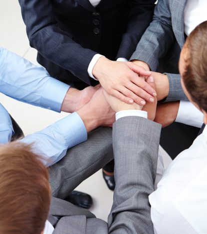 Image of business people hands on top of each other